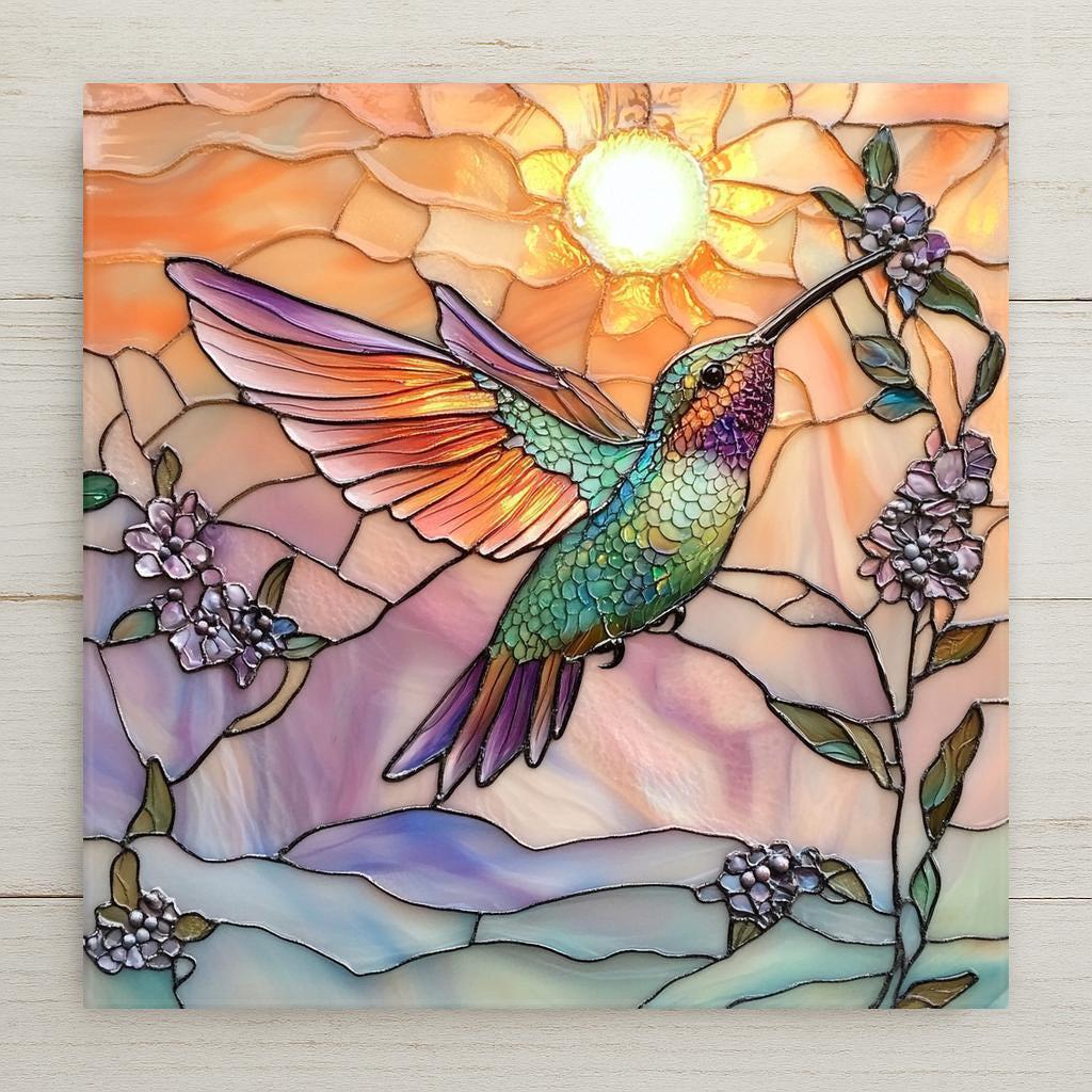 Handcrafted ceramic tile featuring a radiant hummingbird in stained glass style against a warm sunrise sky. A perfect bird lover gift or nature wall art.