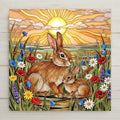 Stained glass style ceramic art tile of a mother and baby rabbit in a wildflower meadow at sunrise, framed by poppies daisies bluebells and lavender, styled for a woodland nursery.