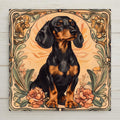Art Nouveau style ceramic art tile of a black and tan dachshund framed by peach flowers and sage foliage — a dog memorial and remembrance keepsake for pet loss.