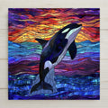 Stained glass orca whale wall art featuring a breaching killer whale and glowing jewel-toned sunset. Permanently printed on ceramic tile for vivid color and lasting beauty. Display with cork backing, tile wall hanger, easel stand, or upgrade to a premium frame for versatile wall or tabletop display. Perfect ocean-inspired decor or gift for marine life lovers.