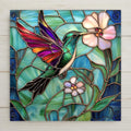 Handmade ceramic tile art featuring a vibrant hummingbird and floral motif in stained glass style. A bold and beautiful gift for spring or garden décor.