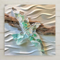 Handcrafted sea glass bird art with driftwood, perfect as outdoor nautical décor or indoor coastal wall art. Ocean-inspired design with frosted glass in aqua, green, and white, bringing seaside charm to beach cottages, patios, or nautical homes.