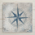 A nautical compass rose ceramic tile featuring a vintage-style blue compass design on a weathered parchment background. The flat printed artwork mimics antique maritime charts and adds classic coastal wall decor appeal. Ideal for beach house home decor or nautical-themed spaces.