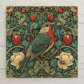 An Art Nouveau songbird botanical wall art ceramic tile featuring a bird nestled among flowing green foliage, cream blossoms, and red strawberries. The stained glass style design highlights intricate botanical patterns and warm, balanced colors. This is a permanent print on ceramic tile, not real stained glass. Optional wall hanger, easel stand, cork backing, and premium frame options are available.
