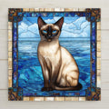 Perfect for cat lovers and art aficionados alike, this ceramic tile features a regal Siamese cat framed in luminous stained glass-style blues. The intricate border and detailed fur shading offer a gallery-quality feel, ideal for elevating your kitchen home decor, hallway, or gallery wall. A stylish home decor accent, trivet, or holiday gift, this piece combines charm and versatility in one memorable item—perfect for birthdays, housewarmings, or just because.
