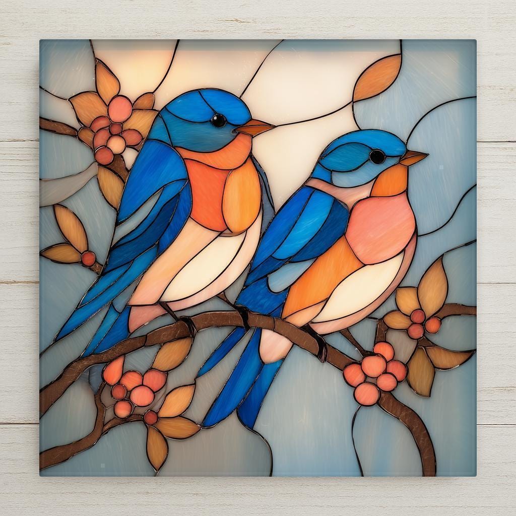 Stained glass-style ceramic tile artwork featuring two bluebirds perched together on a flowering branch. Soft blue, peach, and cream tones create a peaceful, symbolic nature scene printed on a smooth ceramic tile.