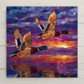 Flying ducks ceramic tile wall art featuring two mallard ducks in a stained glass–style sunset scene over reflective water. Nature-inspired wildlife decor with warm sunset colors. A meaningful home decor gift with optional wall hanger, easel stand, cork backing, or premium frame for display.