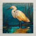 White egret standing in marsh water at sunset in stained glass style with teal water and golden reflections.