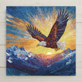 Stained glass style eagle flying over blue mountain peaks at sunrise, symbolizing strength and freedom, printed on a square ceramic tile displayed against a light wood background.