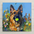 Painterly oil-style ceramic art tile of a German Shepherd holding a tennis ball among colorful wildflowers on a bright blue background, playful dog painting wall decor.