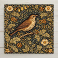 William Morris inspired songbird ceramic tile featuring intricate botanical foliage in deep green and antique gold tones. Vintage bird wall art for cottagecore and traditional home decor.