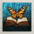 Stained glass style open book ceramic tile with a warm amber gold butterfly emerging from the pages lifting into flight against deep cobalt teal, a vivid book lover memorial gift.