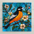 Stained glass style Baltimore oriole ceramic tile with a vivid flame orange and black bird perched on a blossoming spring branch against a deep cobalt and teal sky, warm gold light on the plumage, a vivid bird lover and orange bird decor gift.