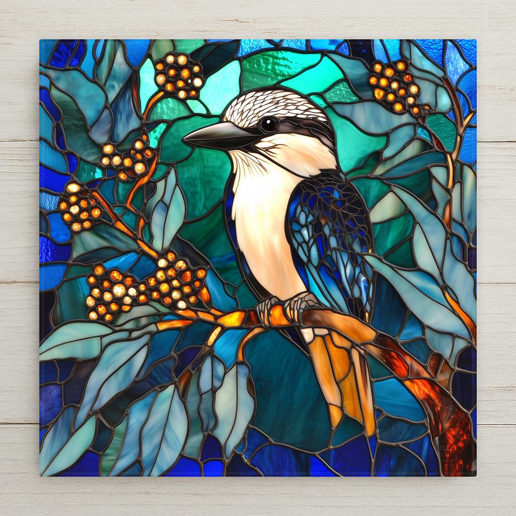 Stained glass style kookaburra ceramic tile with a warm amber and gold kookaburra perched on a eucalyptus branch against deep cobalt teal Australian bush, a vivid Australia bird lover gift.