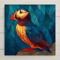 Atlantic puffin ceramic tile wall art in stained glass style showing vivid puffin with jewel tones of orange gold black and white with luminous lead line segmentation against coastal blue