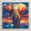 Ceramic art tile depicting a magnificent bull African elephant with large curved tusks walking forward against an amber sunset sky, rendered in jewel-tone stained glass style