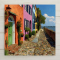 Stained glass style Charleston ceramic tile depicting Rainbow Row's pastel Georgian townhouses glowing in warm afternoon light along East Bay Street, with Charleston Harbor shimmering at the end of the cobblestone lane, rendered in jewel-tone pastels, warm peach, and cobalt blue.