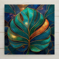 Stained glass style ceramic tile of a large Monstera deliciosa leaf with dramatic split lobes and perforations rendered in deep jewel-tone emerald and jade greens with luminous gold leaded lines, against a rich cobalt and teal background.