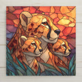 Ceramic art tile depicting a cheetah mother resting in golden savanna grass with two cubs beside her, rendered in jewel-tone stained glass style with warm golden tones