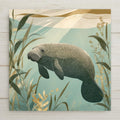 Manatee ceramic art tile floating in sunlit shallows with seagrass in warm grey, seafoam and sandy gold.