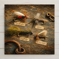 Classic trout fishing flies still life ceramic art tile on weathered wood, Royal Coachman, Adams and Wooly Bugger in olive, amber and red.