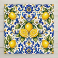 A balanced majolica spray of whole and halved lemons with white blossoms and green leaves in cobalt blue and yellow on a soft cream tile.