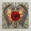 Stained glass style ceramic tile of a single red poppy between a pair of glowing pearlescent angel wings on a cream opal background.