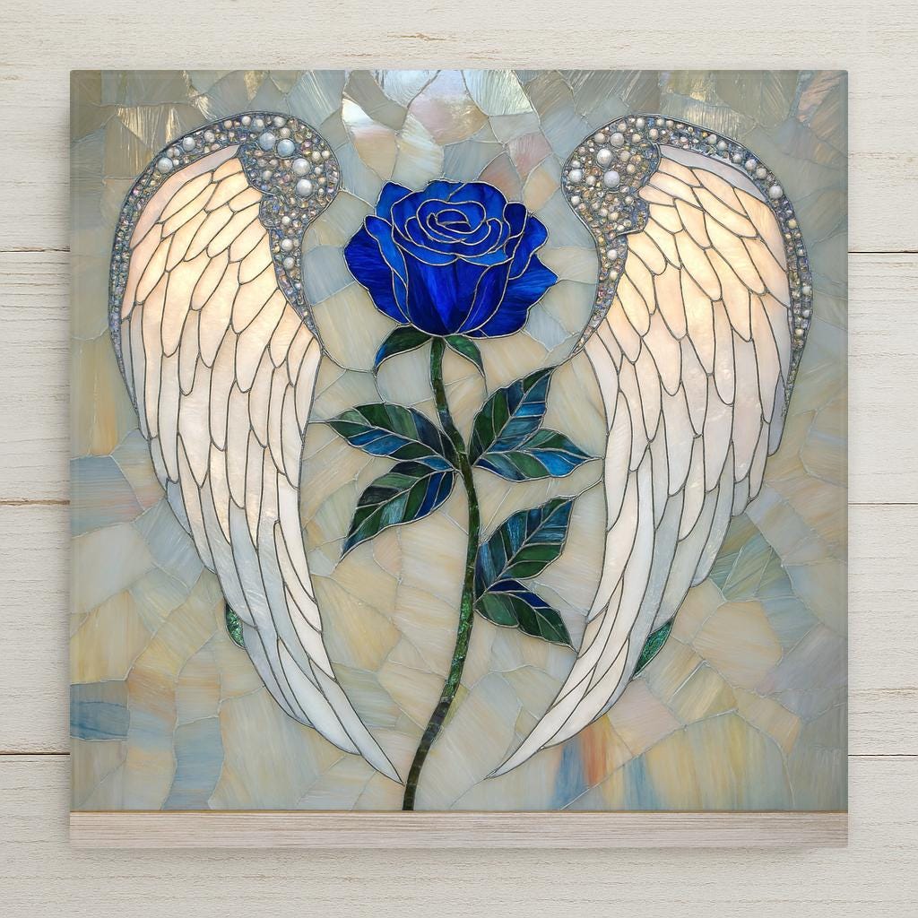 Stained glass style ceramic art tile showing pearl-white angel wings tipped with iridescent jeweled detailing, framing a deep cobalt blue rose on a leafy stem against a soft opal mosaic background. Memorial and remembrance wall art.