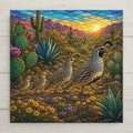 Stained glass style ceramic art tile of a Gambel's quail family walking in a line past blooming prickly pear and blue agave with saguaro and desert mountains at sunrise
