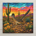 Stained glass style ceramic art tile of a greater roadrunner striding past saguaro cactus and desert marigolds under a turquoise and orange banded Sonoran desert sky